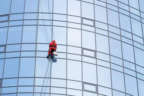 Portrait of a worker cleaning the windows of a modern building. Stock Photos