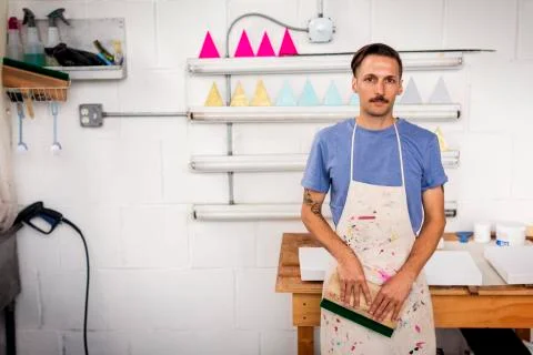 Portrait of worker holding squeegee while standing in workshop Foto stock