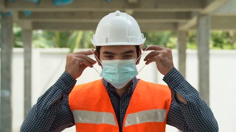 Portrait of worker man wearing protective face mask in construction site duri Stock Footage 147331747