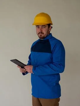 Portrait of worker or engineer in blue work clothes and yellow safety helmet Stock Photos