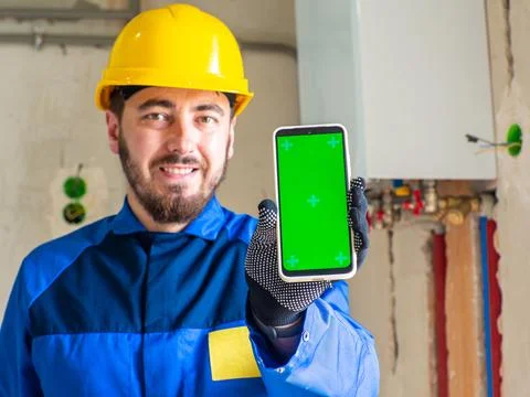 Portrait of worker or engineer in blue work clothes and yellow safety helmet Stock Photos