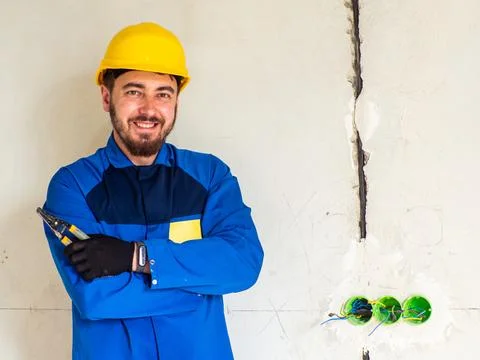 Portrait of worker or engineer in blue work clothes and yellow safety helmet Stock Photos