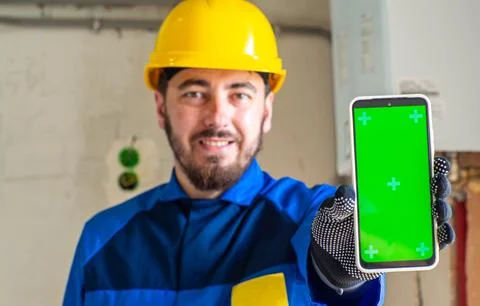 Portrait of worker or engineer in blue work clothes and yellow safety helmet Foto stock