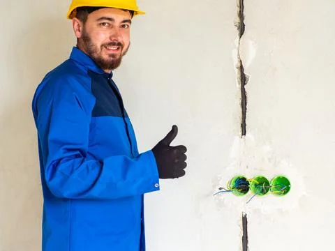 Portrait of worker or engineer in blue work clothes and yellow safety helmet Stock Photos