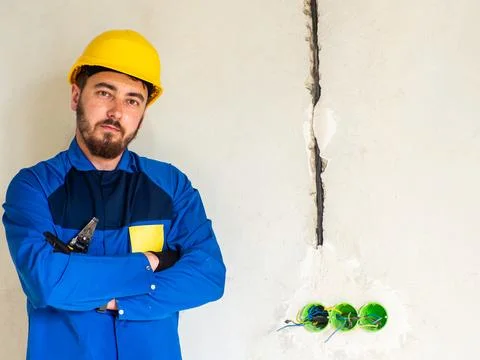 Portrait of worker or engineer in blue work clothes and yellow safety helmet Stock Photos