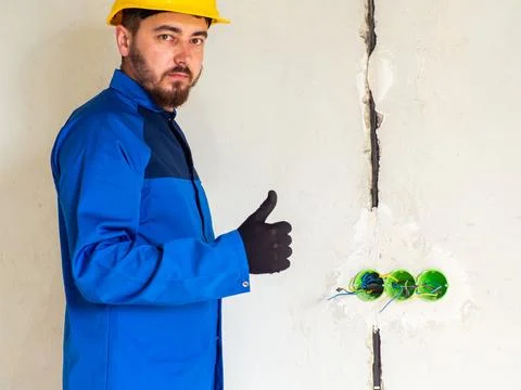 Portrait of worker or engineer in blue work clothes and yellow safety helmet Stock Photos