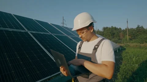 Portrait of a worker servicing solar energy panels with a laptop,side view Stock Footage 264070528