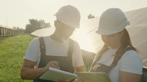 Portrait of workers in front of solar panels discussing information data Stock Footage 255785325