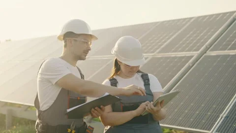 Portrait of workers in front of solar panels discussing information data Stock Footage 257133732