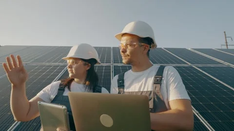 Portrait of workers in front of solar panels discussing information data Stock Footage 263753555