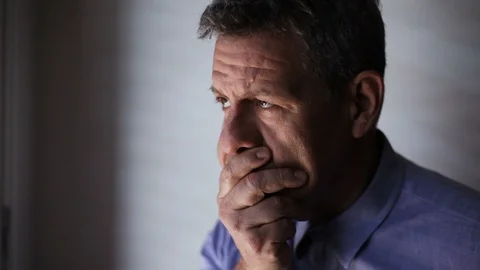 Portrait of an worried elderly man thinking about the problem at the window Video stock 100917134
