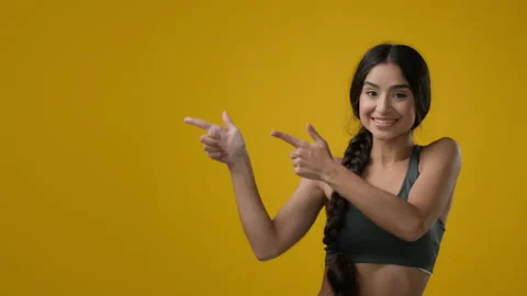 Portrait in yellow studio background Indian happy dancing woman girl point Stock Footage 223671881