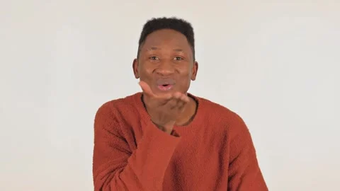 Portrait of Young African Man Blowing Flying Kiss on White Background Video stock 295890597