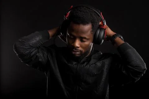 Portrait of young african man listening to music with headphones Stock Photos