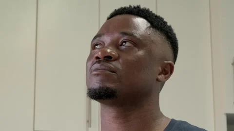 Portrait of young African man looking upward and remembering something indoors, Stock Footage 334651402