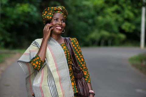 Portrait of young african woman with mobile phone, smiling. Stock Photos