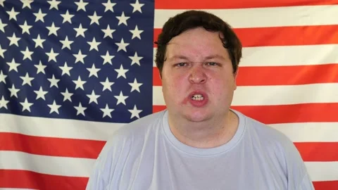 Portrait of young angry man on the background of an USA flag Stock Footage 107089975
