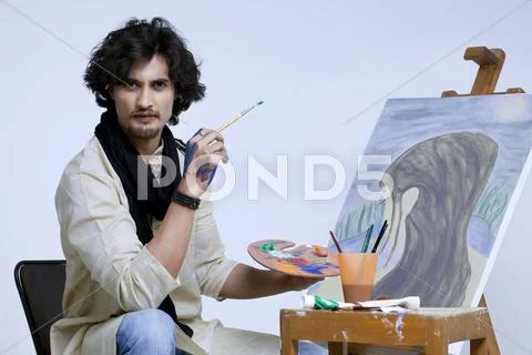 Portrait of young artist with painting against colored background Stock Photos