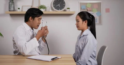 Portrait of young Asian doctor hold stethoscope exam female patient in clinic  Stock Footage