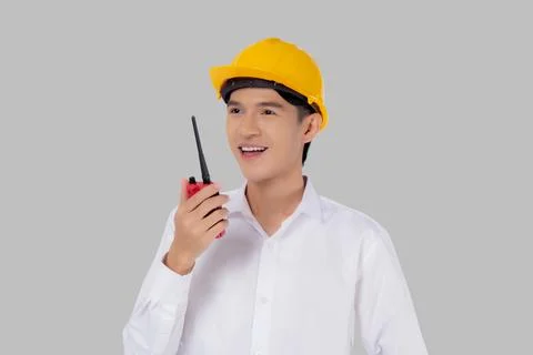 Portrait young asian man is engineer wearing helmet standing and using radio  写真素材