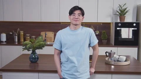Portrait of young asian man looking from down to camera and smiling. Guy in Stock Footage 153470874