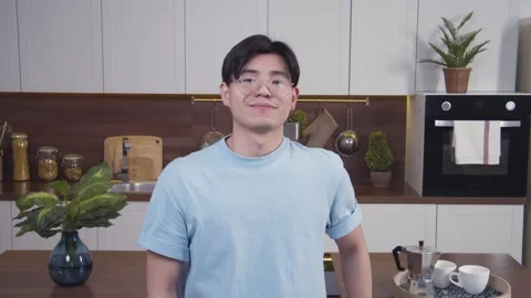 Portrait of young asian man looking from down to camera and smiling. Guy in Stock Footage 153470901
