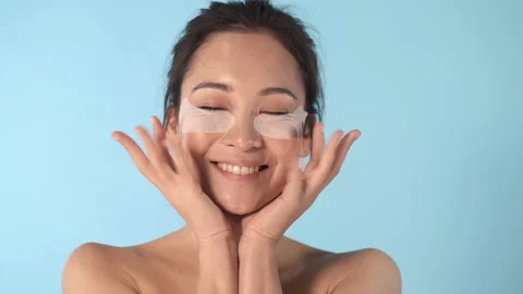 Portrait of young asian model applying eye patches.  Stock Footage 125366449