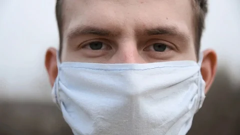 Portrait of a young attractive guy in a self-made medical mask.Close up.Slow mo. Stock Footage 127152130