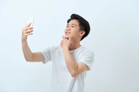 A portrait of a young attractive man taking pictures of him self (selfie) wit Stock Photos