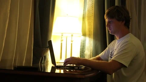 Portrait of young attractive man using the laptop for working in the living room Stock Footage 97084174