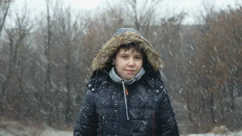 Portrait Of A Young Attractive Man In Winter Clothes Standing Under A Snowfall Stock Footage 124227033