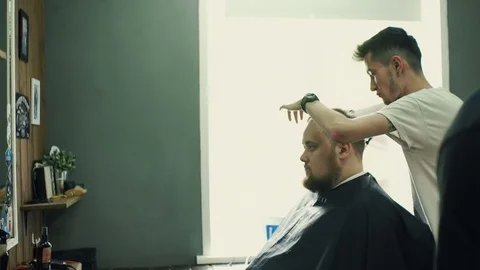 Portrait of young bald bearded man getting shaved with straight edge razor by Stock Footage 69765692