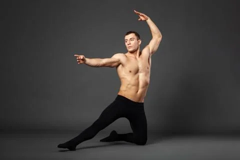 Portrait of a young ballet dancer dancing against a gray background. Stock Photos