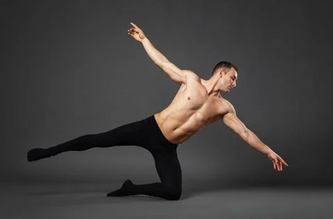 Portrait of a young ballet dancer dancing against a gray background. Stock Photos