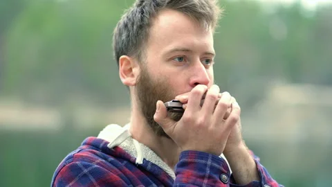 Portrait of young beard man playing on the harmonica. Stock Footage 106091123