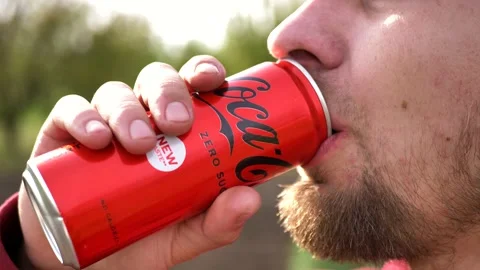Portrait of a young bearded man drinking Coca-Cola ZERO red can of sweet Stock Footage 194240091