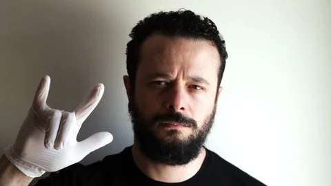 Portrait Of Young Bearded Man Gesturing Rock And Roll Sign Stock-Footage 127470547