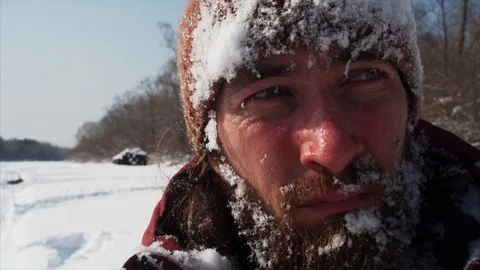 Portrait of young bearded man in warm hat. Beard and hat are covered with snow Stock Footage 124350851