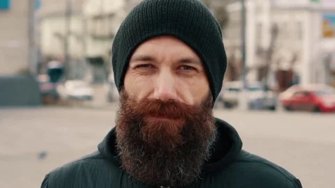 Portrait of a young bearded smiling man on the street Video stock 84320768