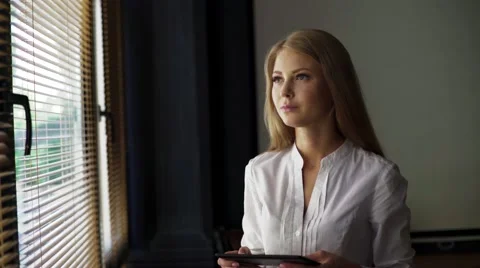 Portrait of a young beautiful blonde women reading electronic book on her Stock Footage