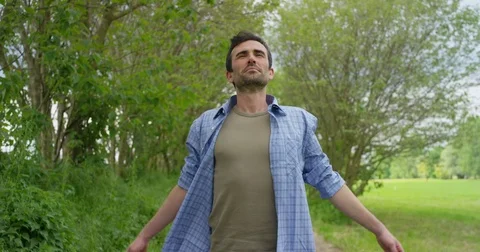 A portrait of a young beautiful farmer sits in a shirt and inhales air, Stock Footage