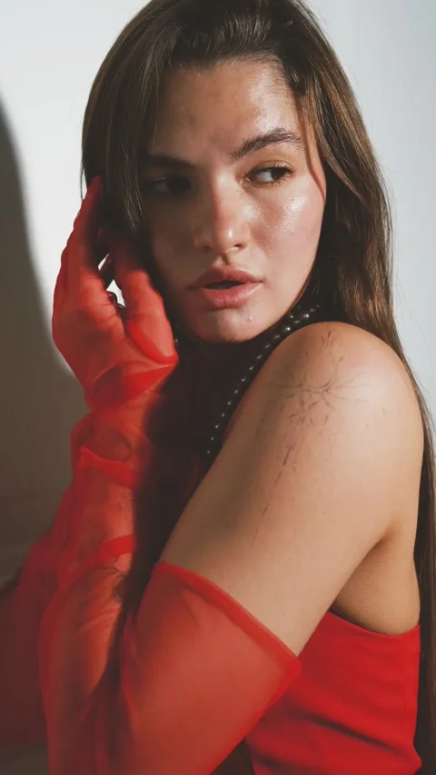 Portrait of a young beautiful model posing in lingerie, in red gloves and a vest Vidéo 288814280