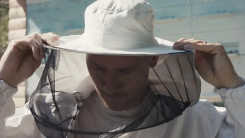 Portrait of a young beekeeper put on protective clothing Stock Footage 136935141