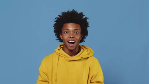 Portrait of a young black guy feeling shocked and surprised, and grabbing his Stock Footage 256909817