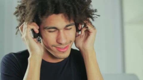 Portrait of a young black guy who listens to music on headphones Video stock 58587016