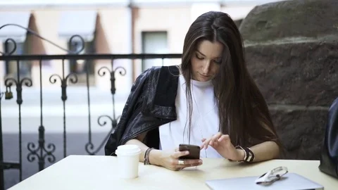 Portrait of a young black haired woman in a cafe with a smartphone Stock Footage