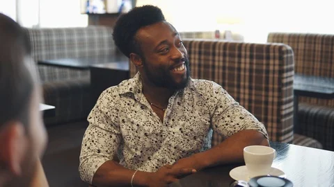 Portrait of a young black man at a table in a cafe or restaurant Stock Footage 91185405