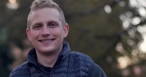 Portrait of a young blond man smiling and laughing nervously Stock Footage 104579151