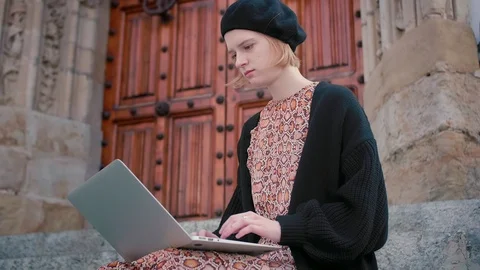 Portrait of young blond short haired Caucasian student sitting on stairs with Stock Footage 105059307