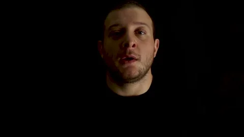 Portrait of young, bored man on black background. Tired and outworn concept. Video stock 132215212